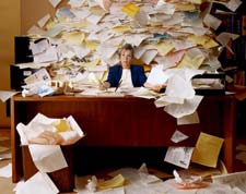 Desk buried under paper